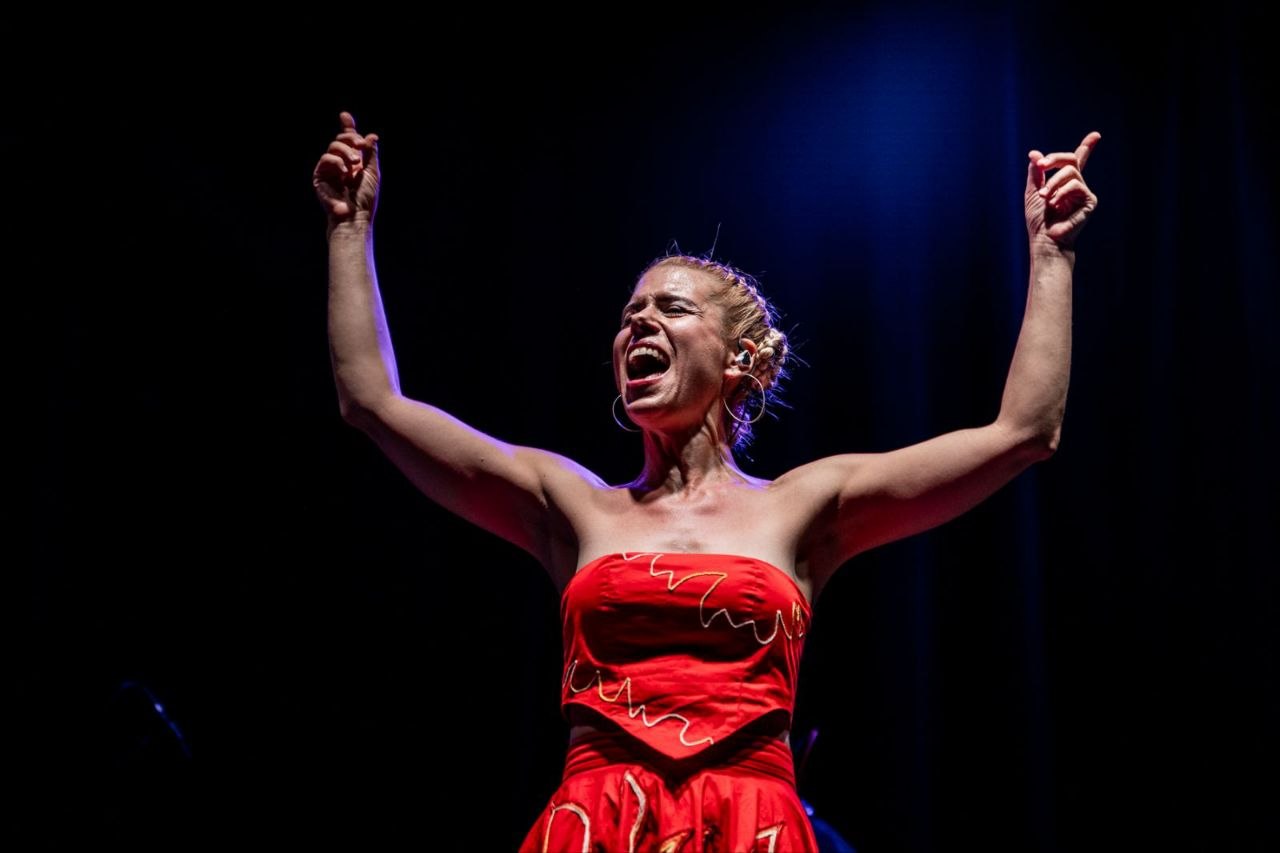 Ana singing with great energy on stage